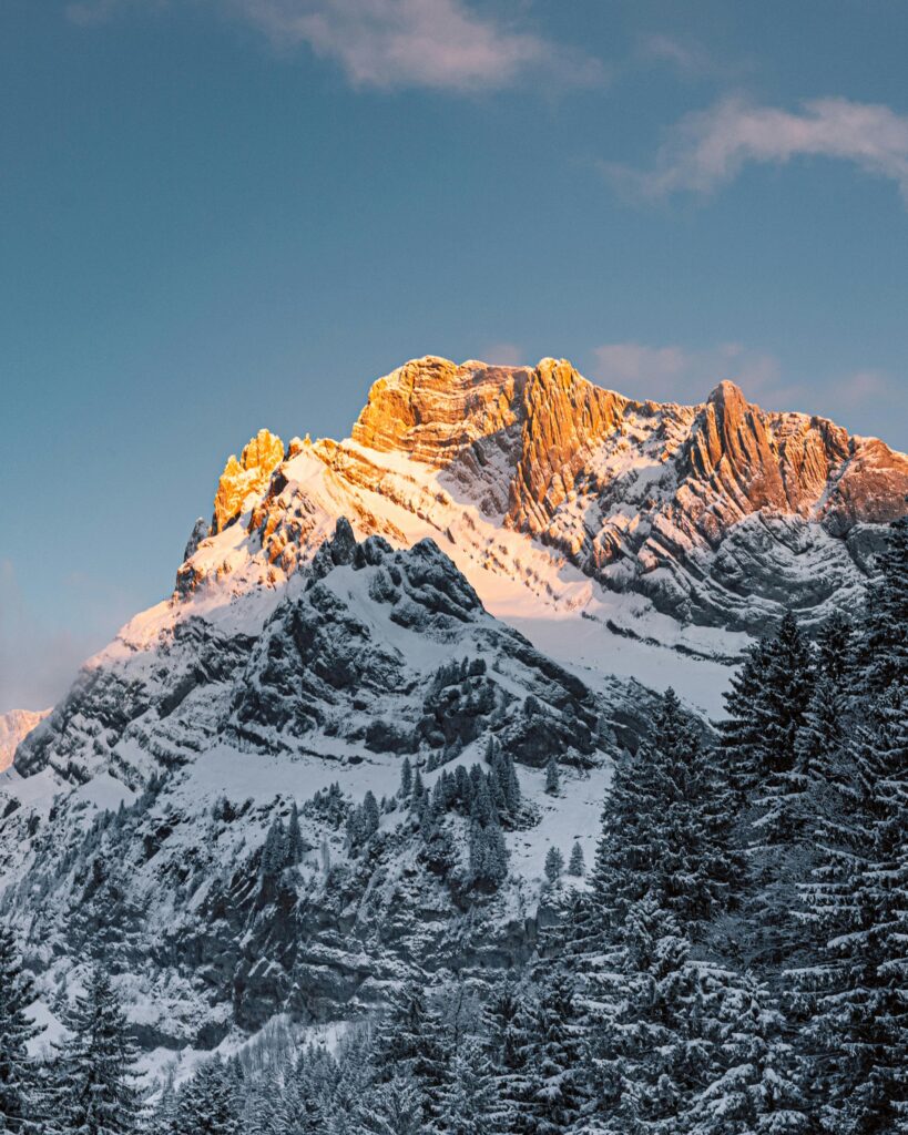 Scenic view of snow-covered mountains at sunrise, capturing Switzerland's natural beauty.