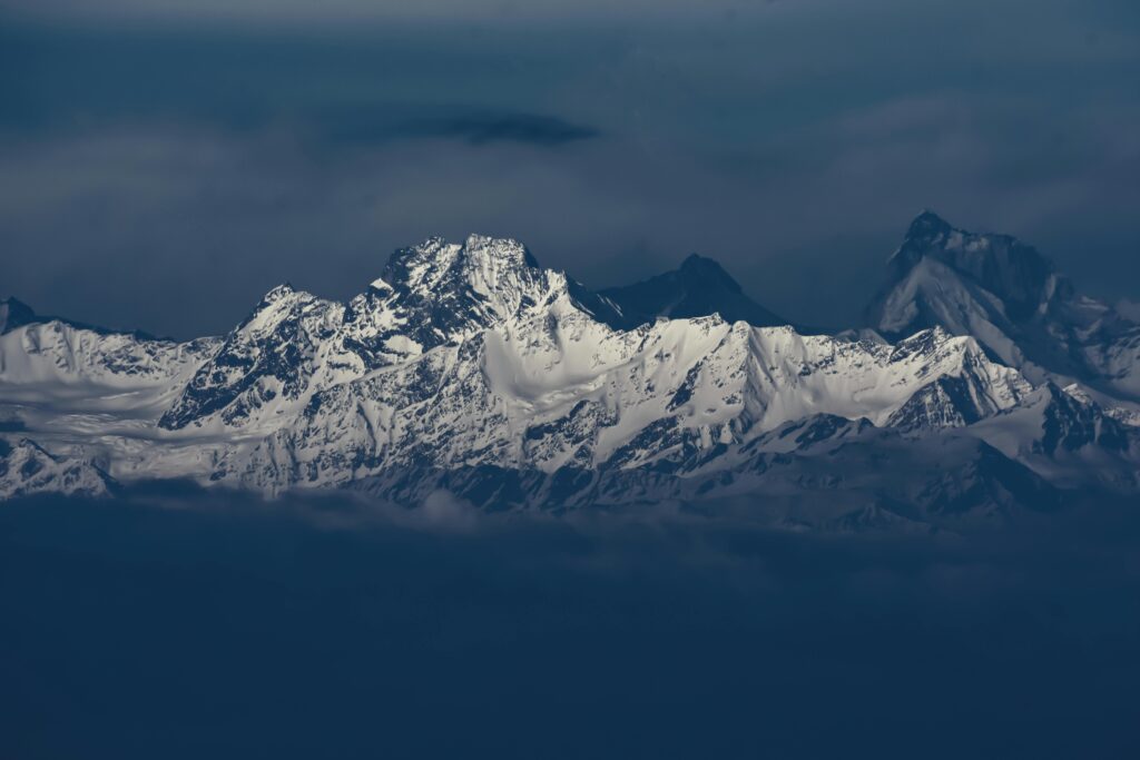Breathtaking snow-covered mountains rising majestically under a moody sky, displaying nature's grandeur.